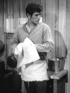 a man standing in front of a stove with pots and pans on it