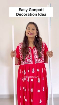 a woman in a red dress holding up a sign with the words easy ganpai decoration idea