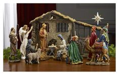 a nativity scene with figurines of people and animals in front of a house