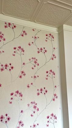 the wall paper has pink flowers on it