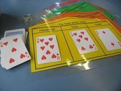 four playing cards are sitting on the table next to each other, and there is a plastic bag containing them