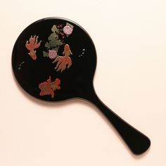 a black spatula filled with different colored stickers on top of a white table