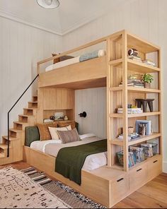 a bedroom with a bunk bed and bookshelf next to stairs in the room