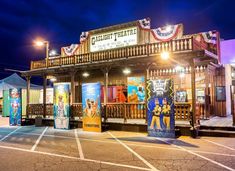 an outdoor theater is lit up at night with colorful lights and banners on the building