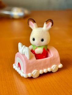 a small toy rabbit sitting on top of a wooden table