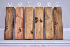 four pieces of wood are lined up against the wall, with numbers on each side