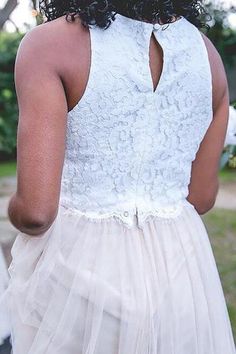 the back of a woman's wedding dress, with her hand on her hip