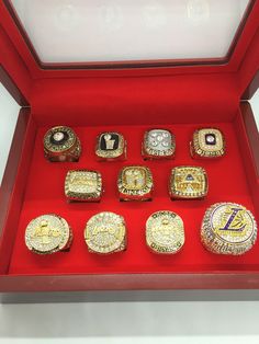 a display case with twelve different rings in red and gold colors on the bottom, one ring is surrounded by smaller ones