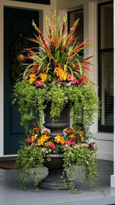 a tall planter filled with lots of colorful flowers