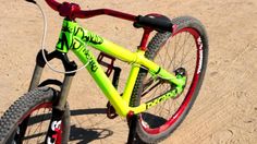 a yellow and red bike sitting on top of a sandy beach