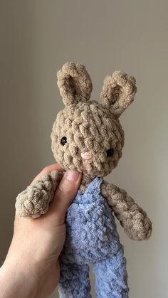 a hand holding a small crocheted stuffed animal in it's right hand