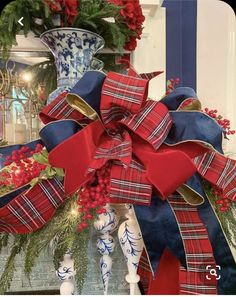 a red, white and blue christmas bow sitting on top of a mantle