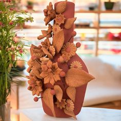 a vase filled with flowers sitting on top of a table next to a potted plant