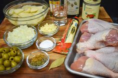 raw chicken, olives, potatoes and other ingredients on a cutting board