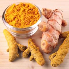 ginger root and tumerical powder on wooden table