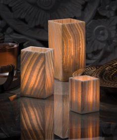 three wooden cubes sitting on top of a table next to a cup and saucer