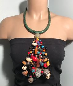 "Immerse yourself in the rich tapestry of African culture with our handmade necklace. Crafted with meticulous detail, this piece showcases traditional craftsmanship, vibrant colors, and intricate beadwork. Each bead tells a story, making this necklace not just an accessory but a cultural statement. Embrace the spirit of Africa and adorn yourself with a unique piece that reflects heritage and style. Perfect for those who appreciate the artistry and diversity of African jewelry." Material: Glass b Hippie Style Green Beaded Necklace For Festivals, Green Beaded Hippie Necklace, Hippie Style Green Beaded Necklaces With Round Beads, Unique Bib Necklace With Large Beads For Festivals, Unique Bib Necklaces With Large Beads For Festivals, Hippie Green Beaded Necklace, Bohemian Beaded Chain For Crafting, Bohemian Bib Necklaces With Colorful Round Beads, Unique Colorful Beaded Necklaces For Festivals