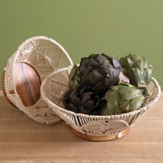 two baskets with succulents in them on a table