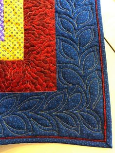 a close up of a quilted piece of cloth with different colors and designs on it