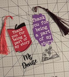 two bookmarks with words and tassels on them