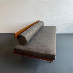 a couch that is sitting on some kind of wood frame with a rolled up rug