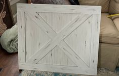 a white barn door sitting on top of a wooden floor next to a chair and rug