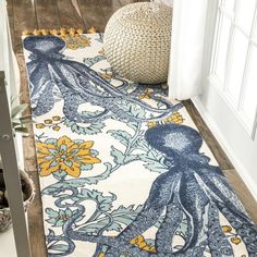 an octopus rug is on the floor in front of a door with a vase and potted plant