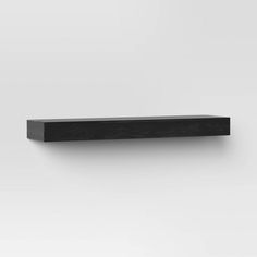 a black shelf sitting on top of a white wall