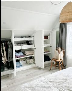 an attic bedroom with white walls and open closets