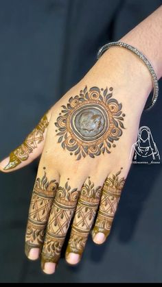 a woman's hand with henna tattoos on it