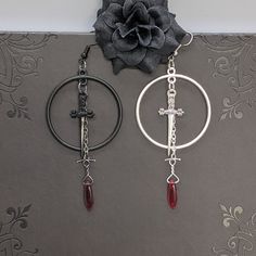 Embrace your Darker Side with these piercing Dagger Hoop Earrings. Wear casual or dressy, whatever your heart desires. Look like a true Goddess of Darkness and pair with our Chokers, Necklaces, Bracelets, and Rings. Embrace the Darker Side! Details: Fashion Jewelry ~ Handmade Length: approx. 88mm Dagger Charm: approx. 35x13mm Hoops Diameter: approx. 35mm Ruby Dagger Bead: 15.5x5mm Rocker Jewelry, Dagger Earrings, Dark Jewelry, Bracelets And Rings, Goth Jewelry, Punk Jewelry, Handmade Fashion Jewelry, Spooky Vibes, Black Jewelry