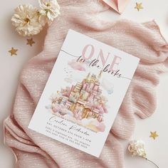 a pink and white wedding save the date card on top of a pink blanket next to flowers