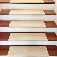 a set of stairs with carpeted treads and wooden handrails on each step