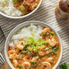 two bowls filled with shrimp and rice on top of a table