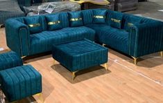 a living room with blue velvet couches and matching footstools on the floor