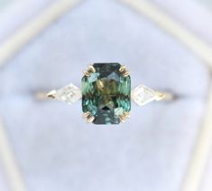 a fancy ring with an emerald colored diamond