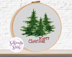 a cross stitch christmas tree with merry lettering