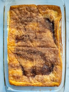 a square casserole dish filled with food on top of a blue tablecloth