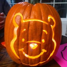 a carved pumpkin with a bear face on it