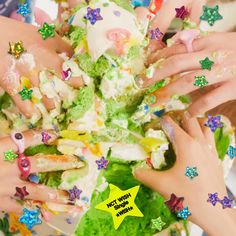 several people with their hands on the top of a bowl filled with food and stars