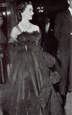 an old black and white photo of a woman in a dress