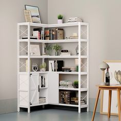 a white book shelf with books on top and various other items in the room next to it