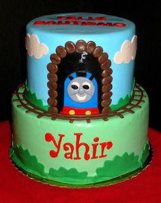 a thomas the train birthday cake on a red tablecloth with a name and number