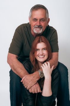 an older man and young woman are posing for a photo with their arms around each other