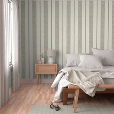 a white bed sitting in a bedroom next to a wooden dresser and lamp on top of a hard wood floor