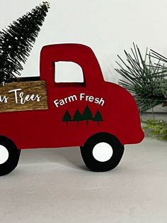 a red toy truck with a christmas tree in the back