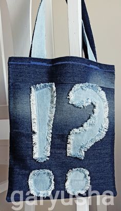 a denim tote bag with the letter s on it and holes in the fabric