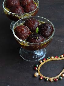 two bowls filled with food next to a beaded bracelet on a black counter top