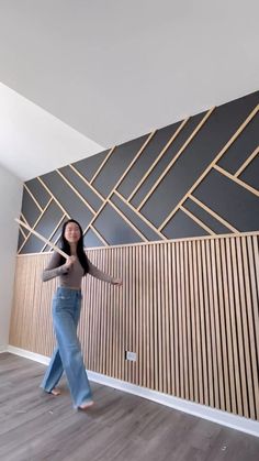 a woman standing in front of a wall with wooden panels on it's sides