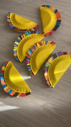 several paper plates are arranged in the shape of banana peels on a wooden table